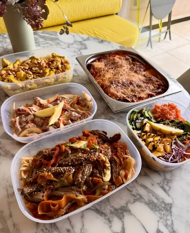 Lasagnes, mijoté de bœuf et salades préparés sur un plan de travail en marbre